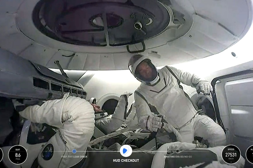 Astronauts engaging in the first private spacewalk